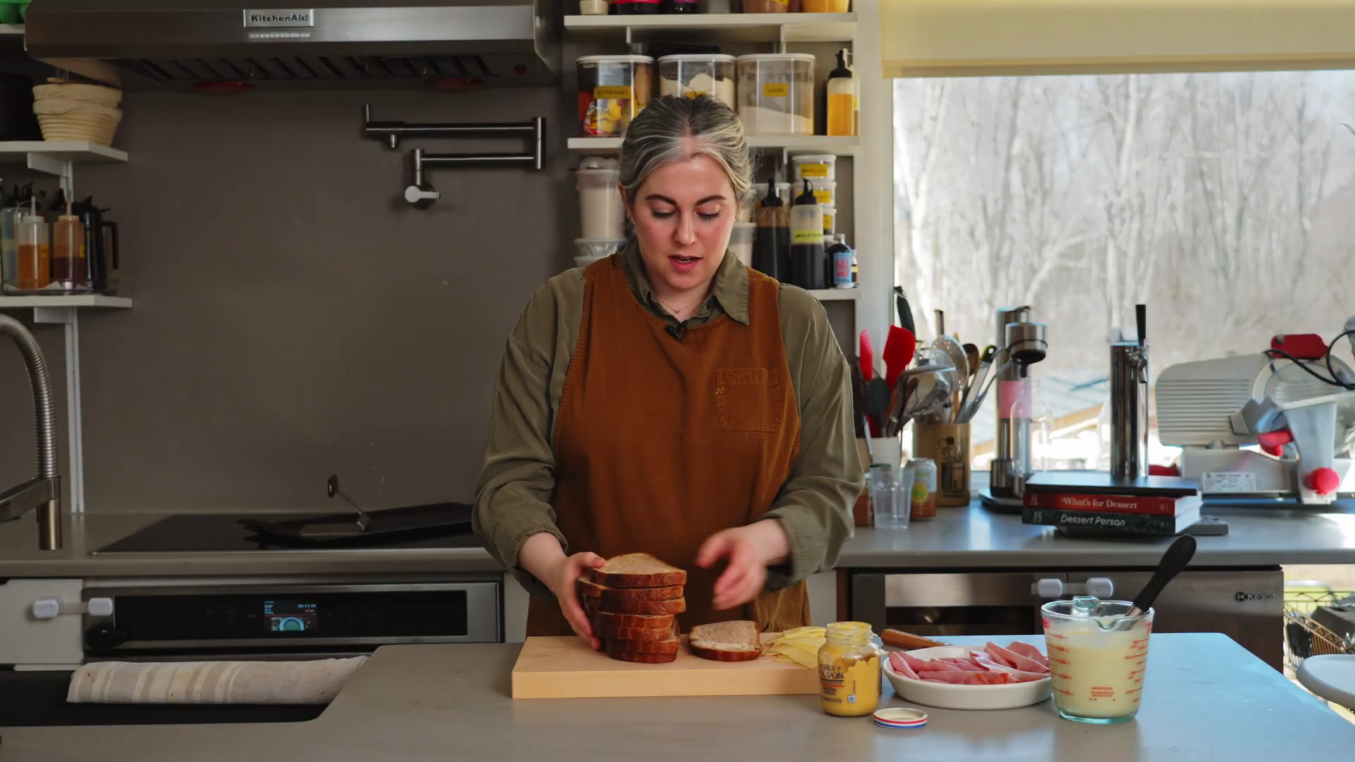 Chef preparing bread and cured ham on a cutting board